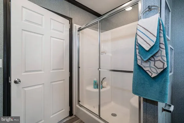 a bathroom with a glass shower door and a window