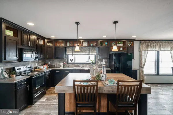 a kitchen with a kitchen island a stove a table and chairs in it