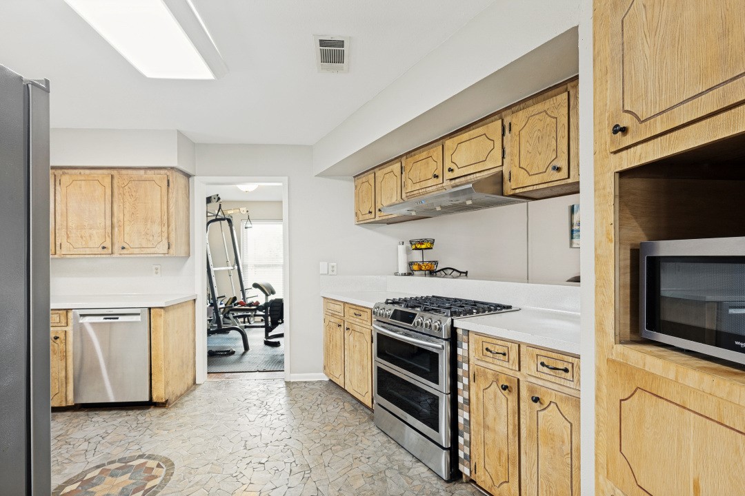 2500 County Road 62 Rosharon, TX 77583 - Photo 22 of 48 a kitchen with stainless steel appliances granite countertop a stove a sink and a microwave