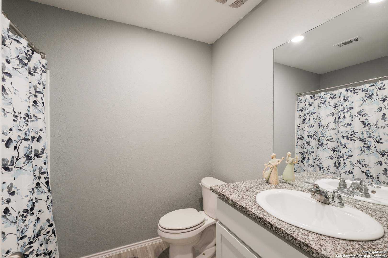 706 Ambush Ridge San Antonio, TX 78220 - Photo 19 of 21 a bathroom with a granite countertop toilet a sink and a mirror