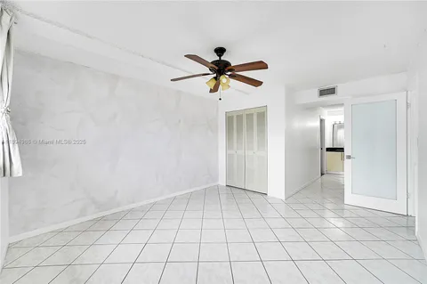 a view of an empty room and chandelier fan