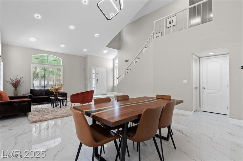 9416 Rolling Ridge Lane Las Vegas, NV 89134 - Photo 5 of 34 Dining space featuring light marble finish floors, recessed lighting, high vaulted ceiling, and stairs