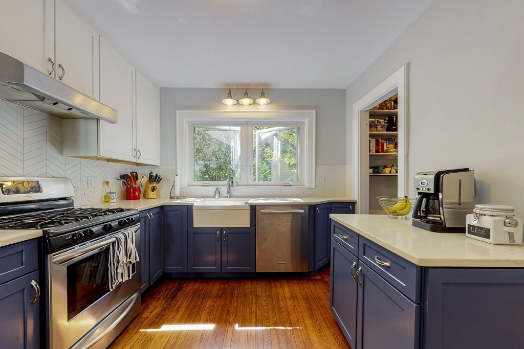 15 Sunset Road, Unit 15 Watertown, MA 02472 - Photo 7 of 25 a kitchen with kitchen island granite countertop a sink cabinets and stainless steel appliances