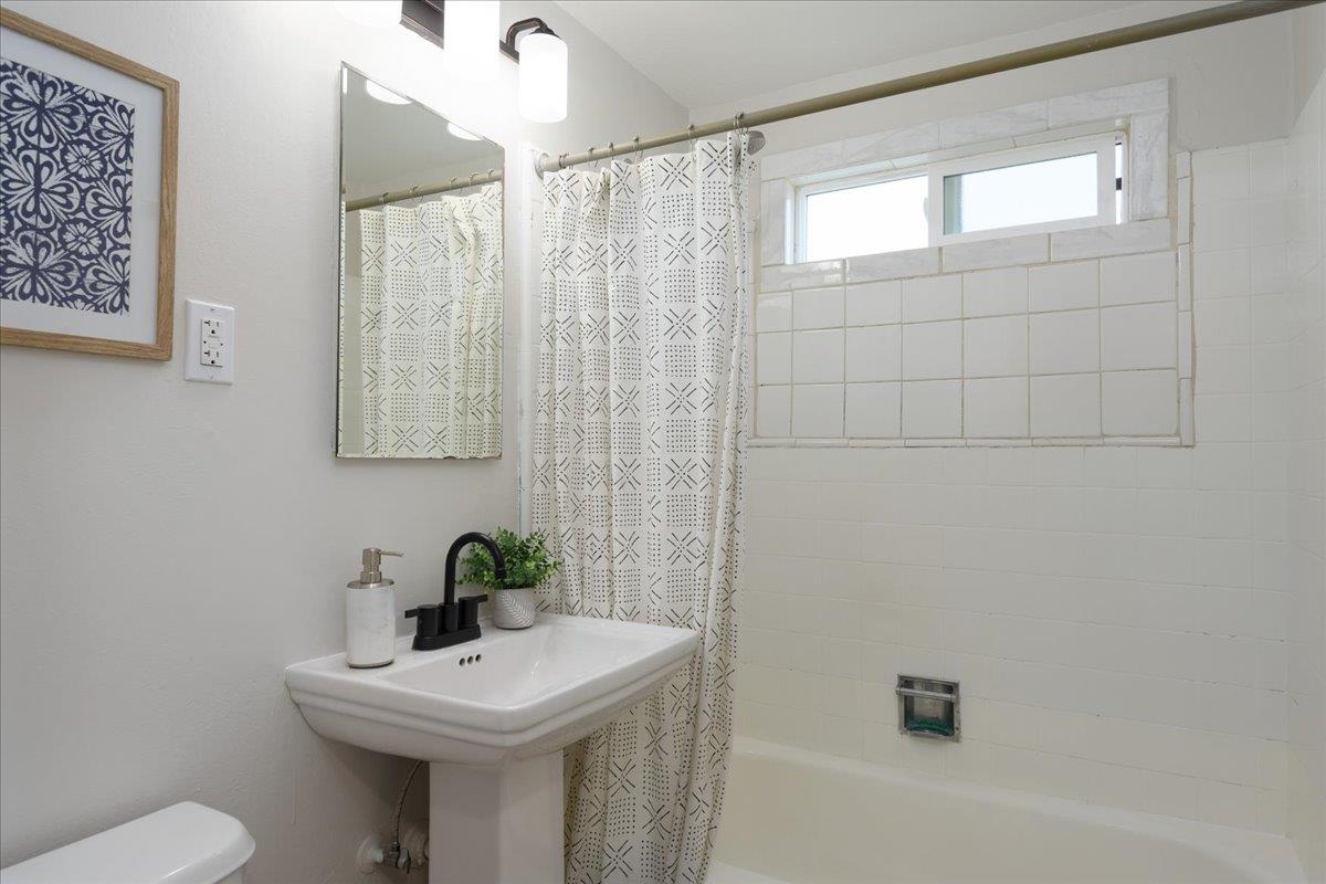 815 Edgemar Avenue Pacifica, CA 94044 - Photo 12 of 27 a bathroom with a sink a mirror and a toilet