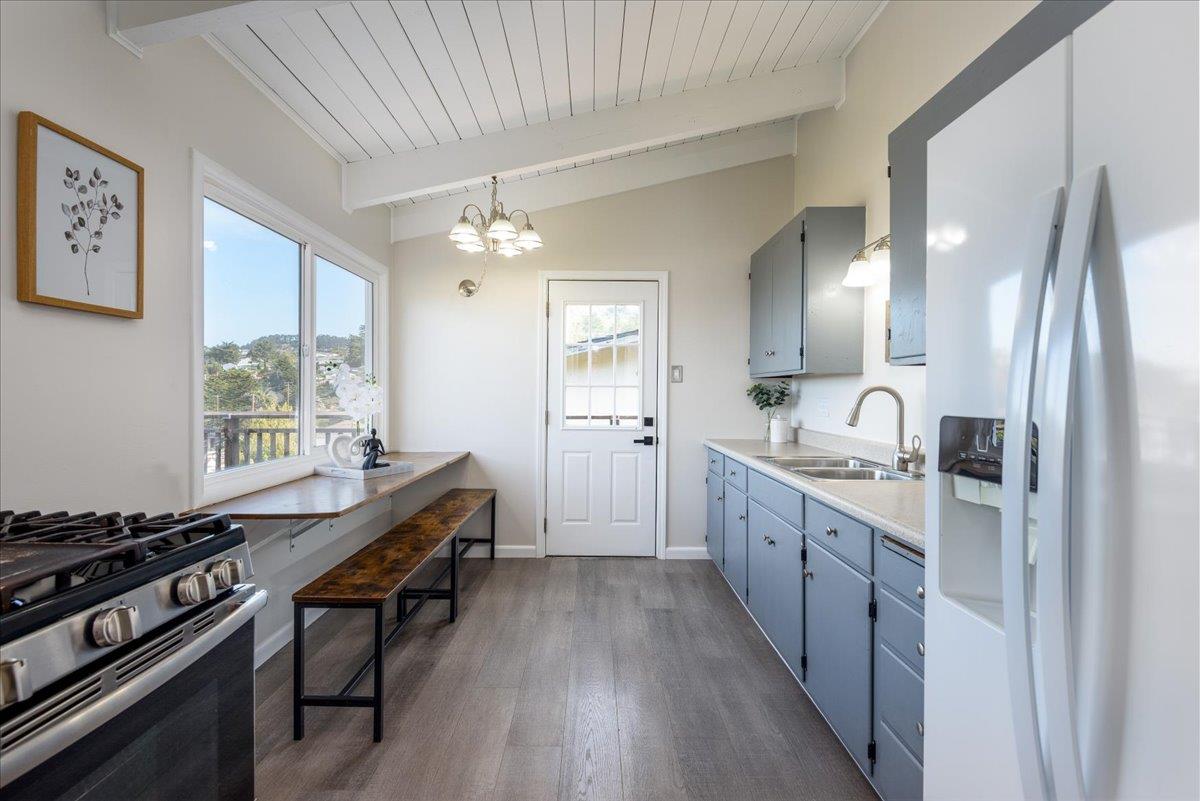 815 Edgemar Avenue Pacifica, CA 94044 - Photo 6 of 27 a large kitchen with granite countertop a stove top oven a sink dishwasher and wooden floor