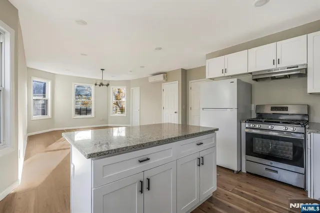 a kitchen with granite countertop a sink stove and refrigerator