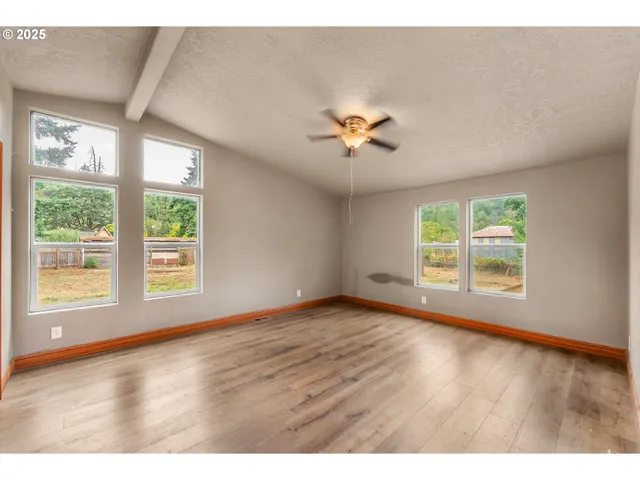a view of an empty room with wooden floor