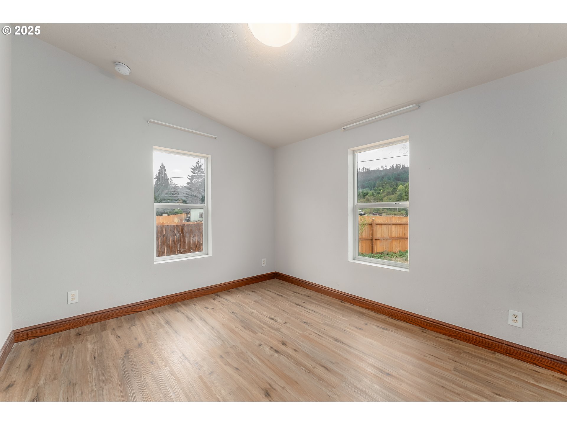 161 South Avenue Sutherlin, OR 97479 - Photo 23 of 45 an empty room with wooden floor and windows