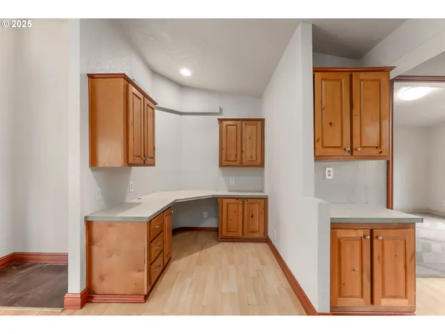 a kitchen view of a refrigerator and a window
