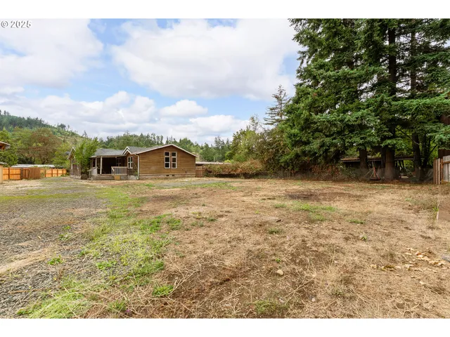 an aerial view of residential house with pool and trees