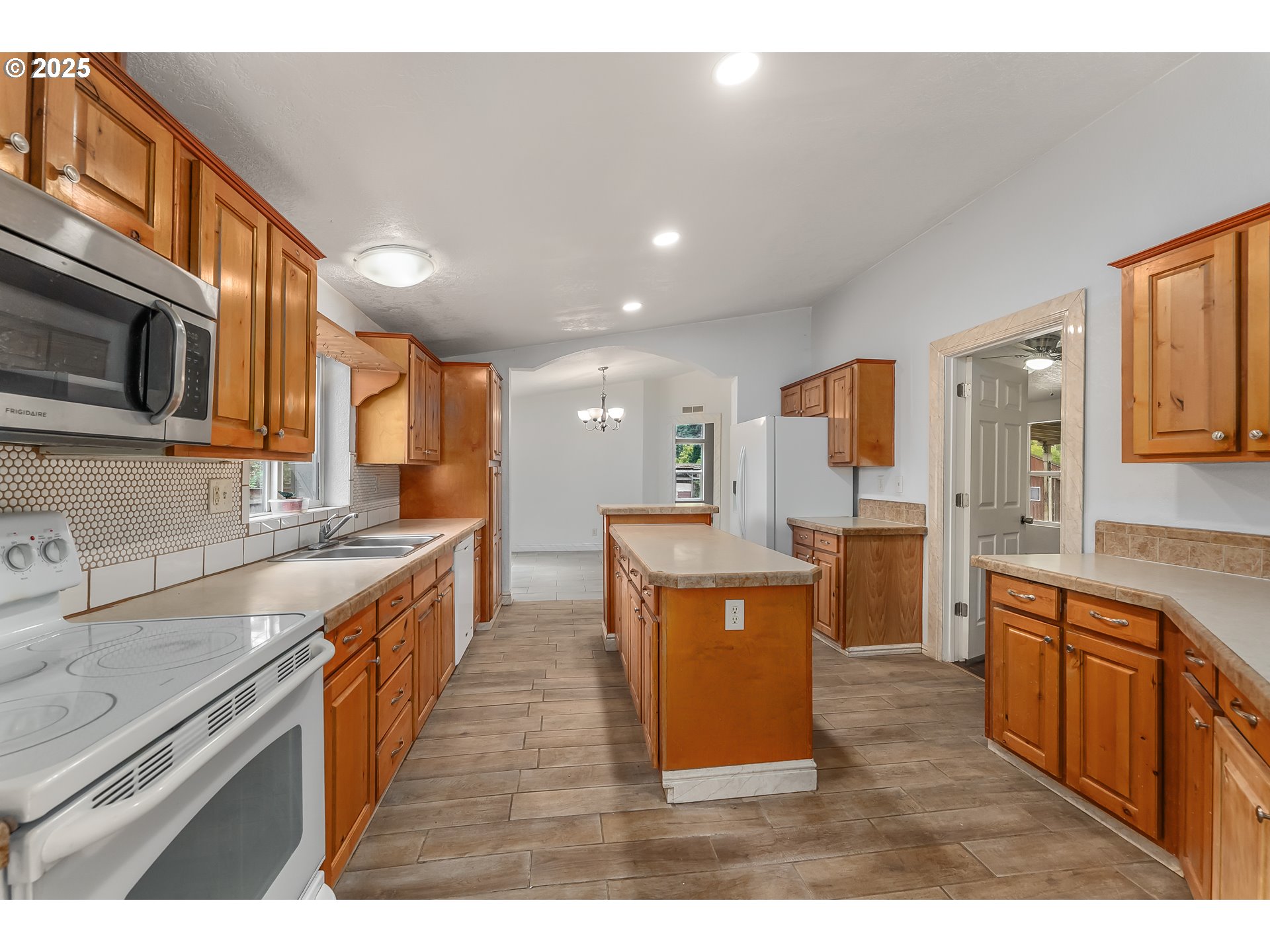 161 South Avenue Sutherlin, OR 97479 - Photo 7 of 45 a kitchen with stainless steel appliances granite countertop a stove top oven a sink dishwasher a refrigerator and a dining table with wooden cabinet