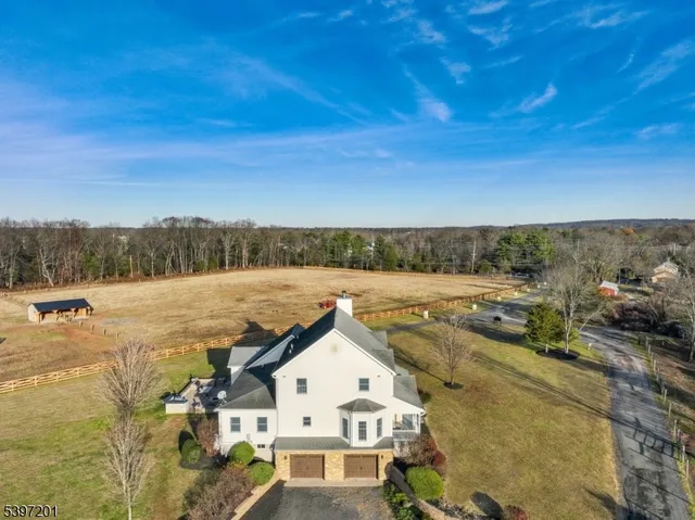 a view of house with river and trees in the background