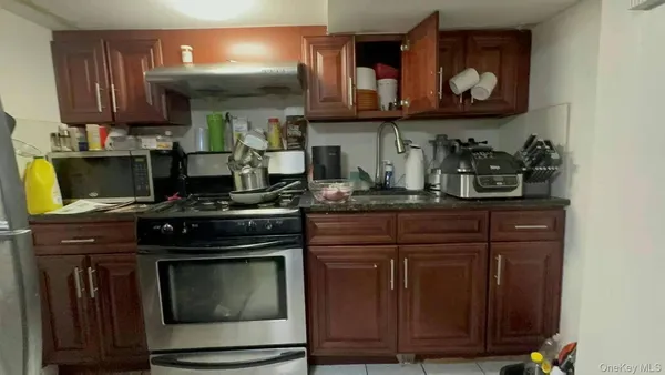 a kitchen with stainless steel appliances granite countertop a stove and a wooden cabinets