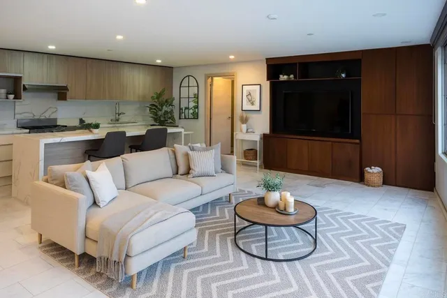 a living room with furniture a rug and kitchen view