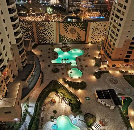 a living room with stainless steel appliances furniture a flat screen tv and a large window