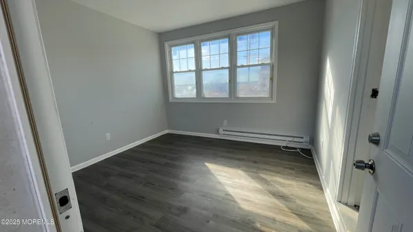 a view of a room with wooden floor and a window