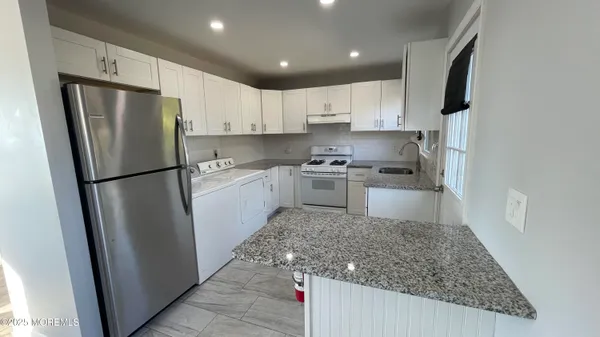 a kitchen with stainless steel appliances granite countertop a refrigerator stove and sink