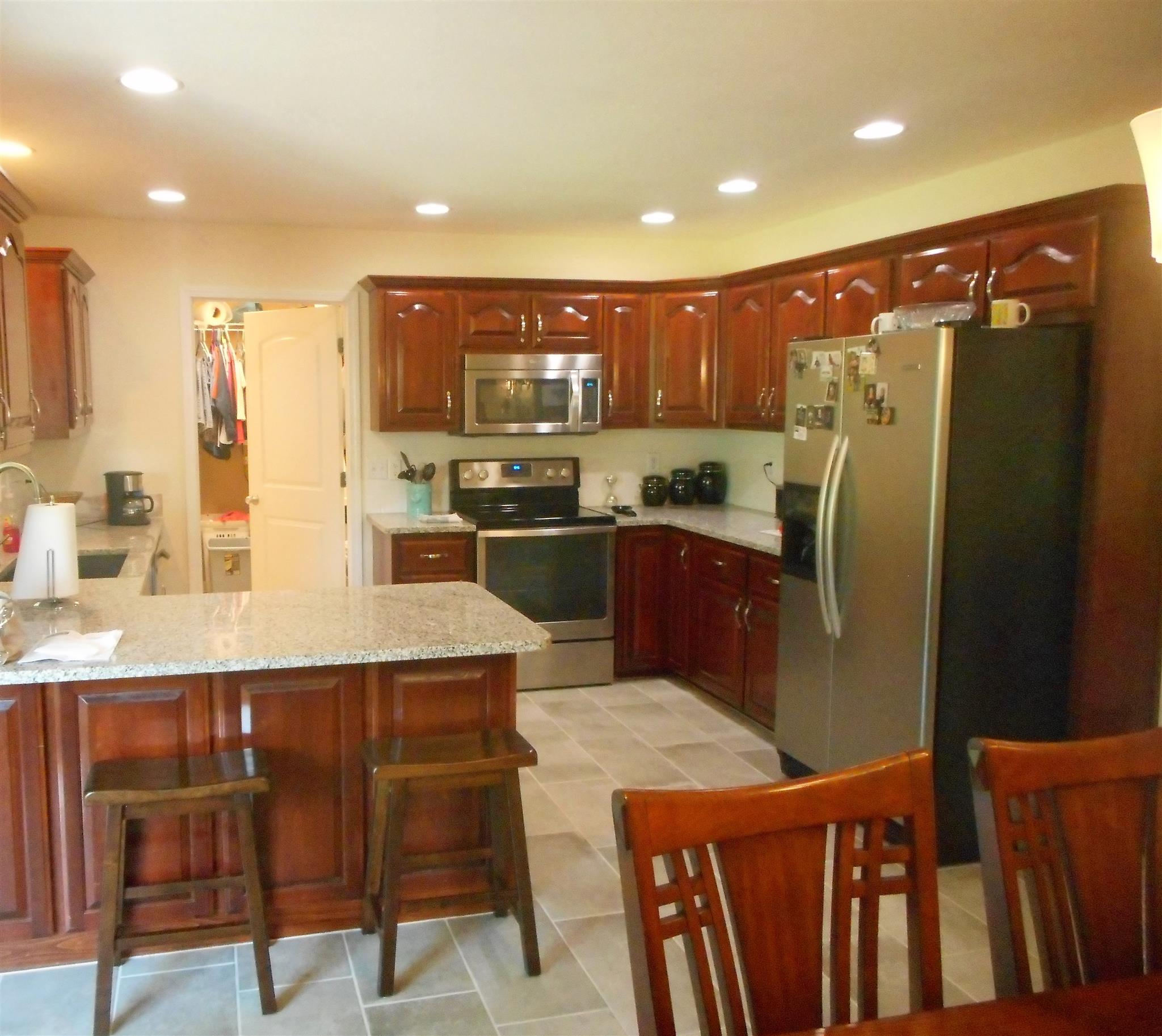 4202 Roy Cole Road Springfield, TN 37172 - Photo 5 of 17 a kitchen with stainless steel appliances granite countertop a refrigerator a sink a stove a dining table and chairs
