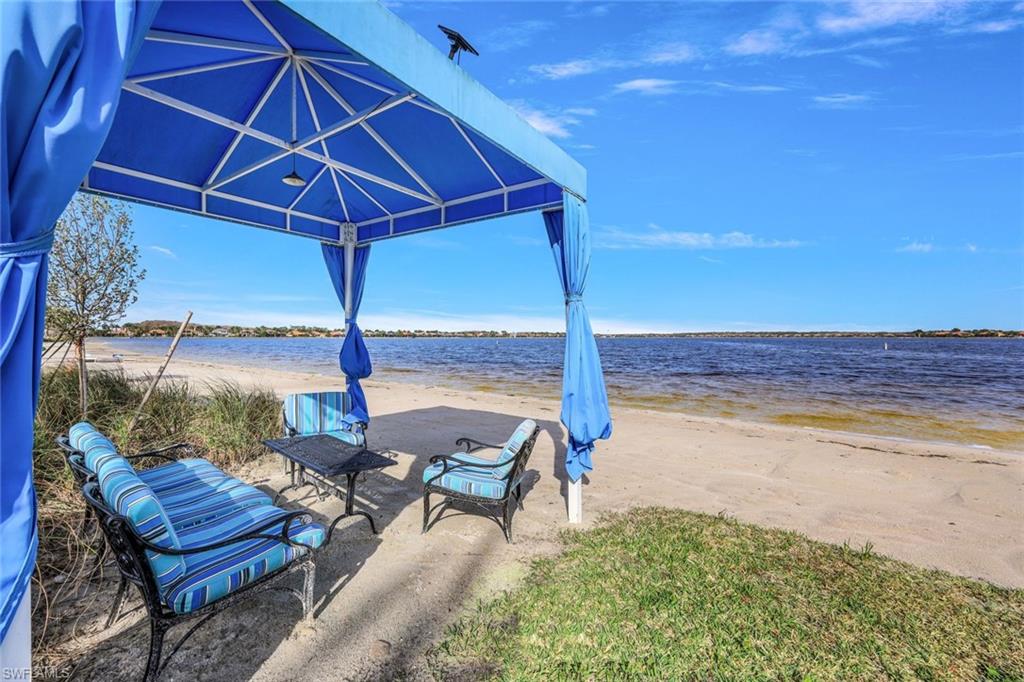 9062 Limestone Lane Naples, FL 34120 - Photo 43 of 48 a view of a backyard with lawn chairs under an umbrella