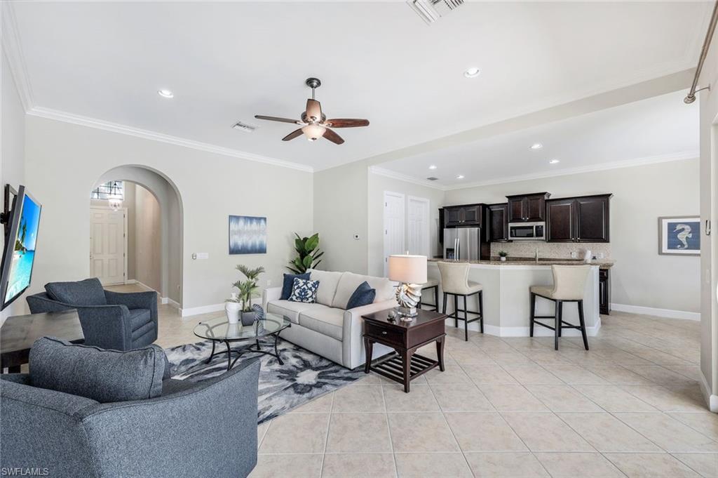 9062 Limestone Lane Naples, FL 34120 - Photo 6 of 48 a living room with furniture and a flat screen tv