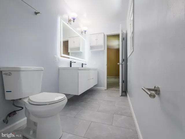 a view of a house with a small yard plants and large trees