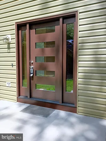 a view of a hallway with wooden floor and entryway