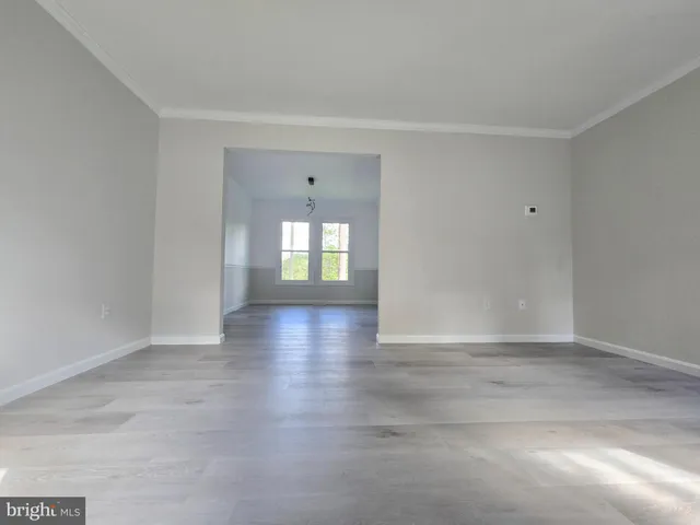 a view of an empty room with a window and fireplace