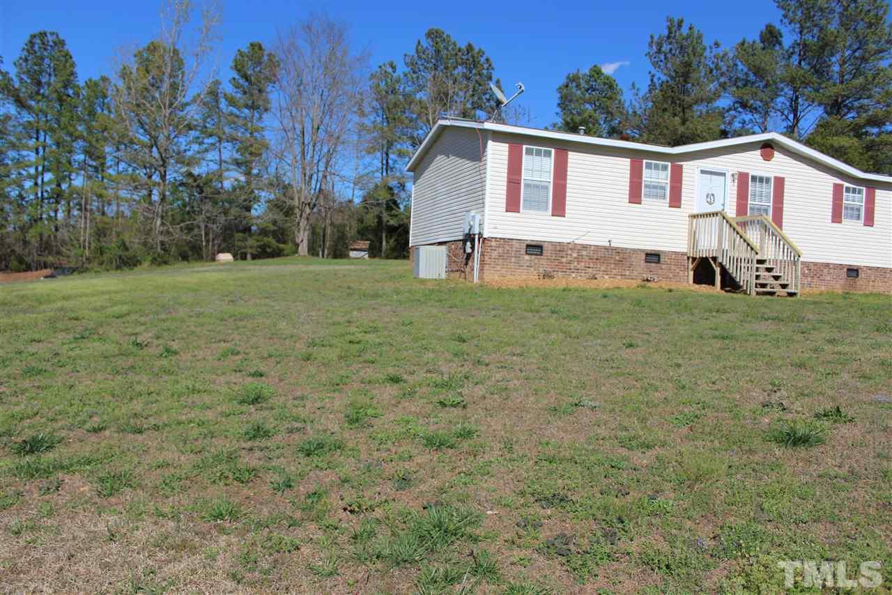 1189 Little Mountain Road Stem, NC 27581 - Photo 2 of 17 a view of a yard in front of a house with large trees