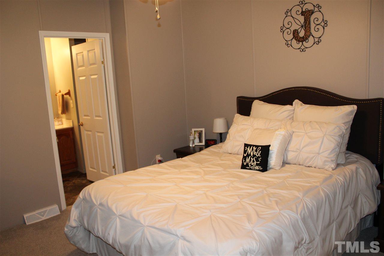 1189 Little Mountain Road Stem, NC 27581 - Photo 12 of 17 a large bed sitting in a bedroom next to a bathroom