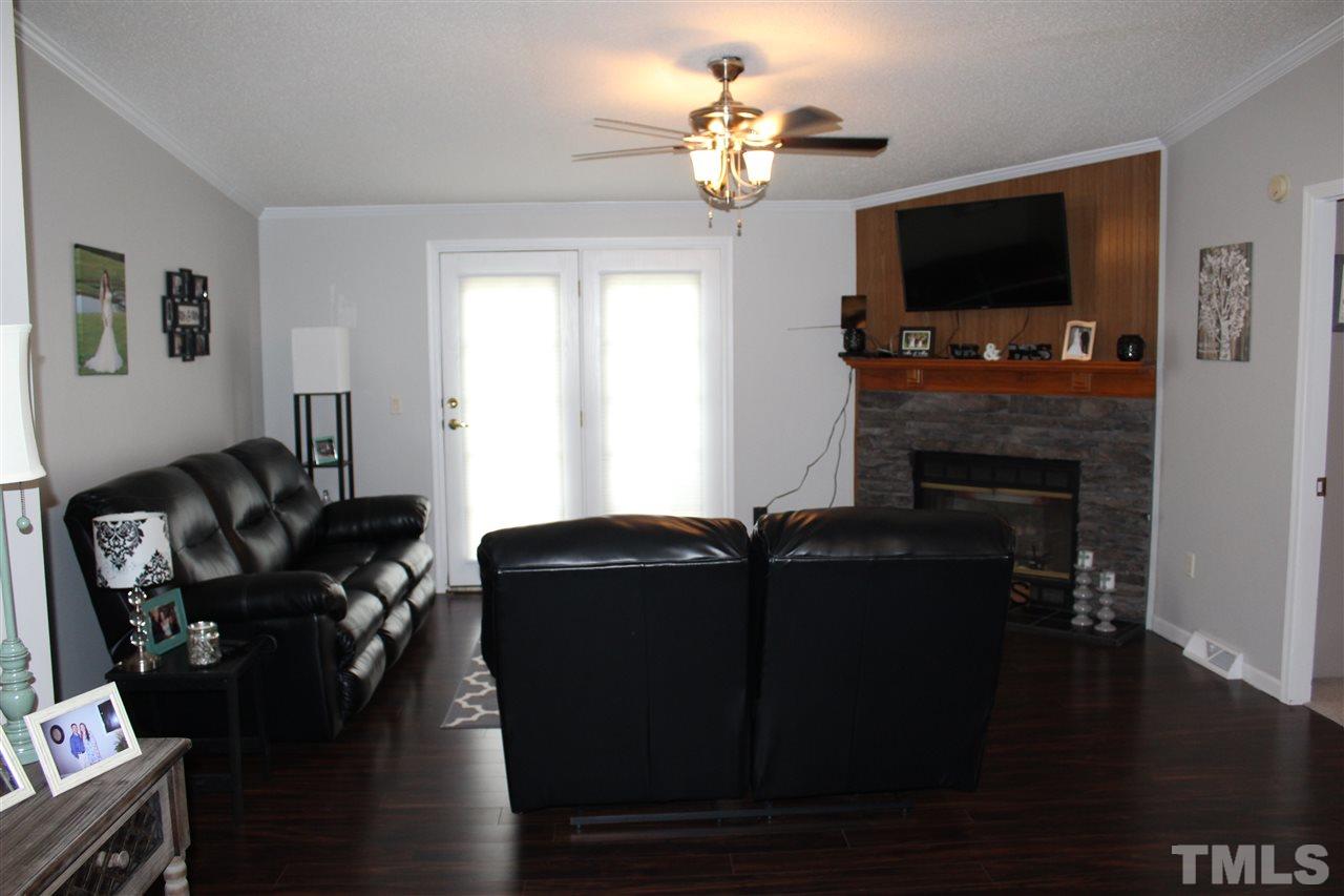 1189 Little Mountain Road Stem, NC 27581 - Photo 7 of 17 a living room with furniture a flat screen tv and a fireplace