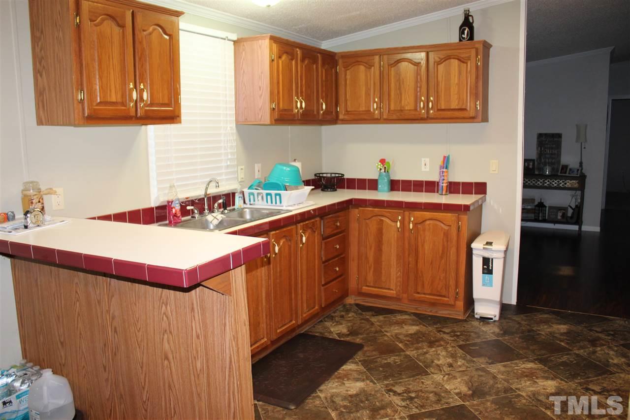 1189 Little Mountain Road Stem, NC 27581 - Photo 10 of 17 a kitchen with stainless steel appliances a sink a stove a refrigerator cabinets and a window