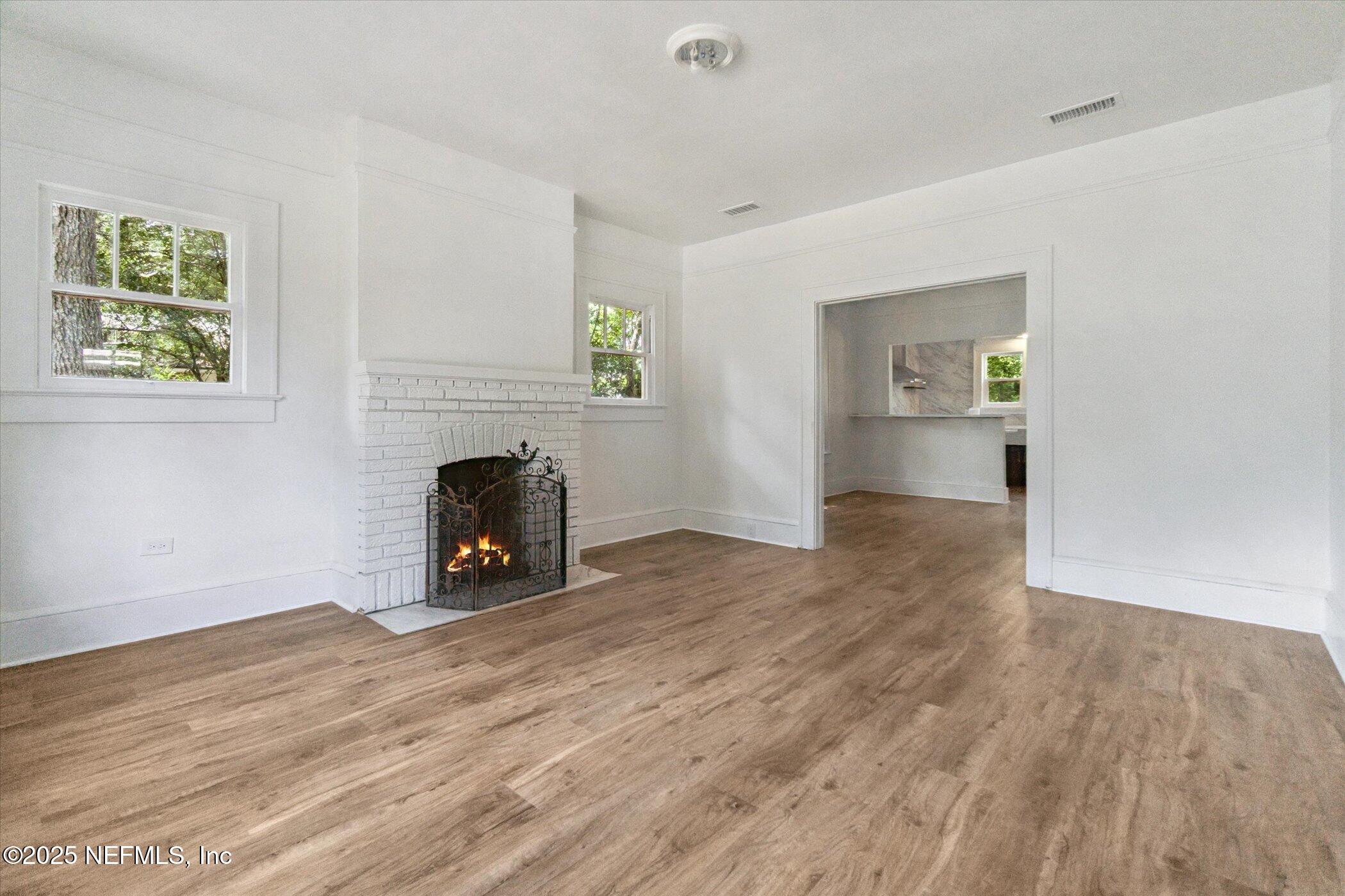 3849 Valencia Road Jacksonville, FL 32205 - Photo 12 of 30 a view of empty room with wooden floor and a fireplace