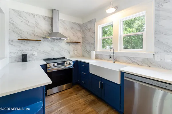 a kitchen with stainless steel appliances sink a stove and a window