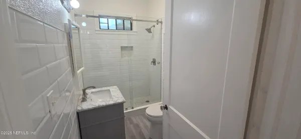 a bathroom with a granite countertop sink a toilet and shower