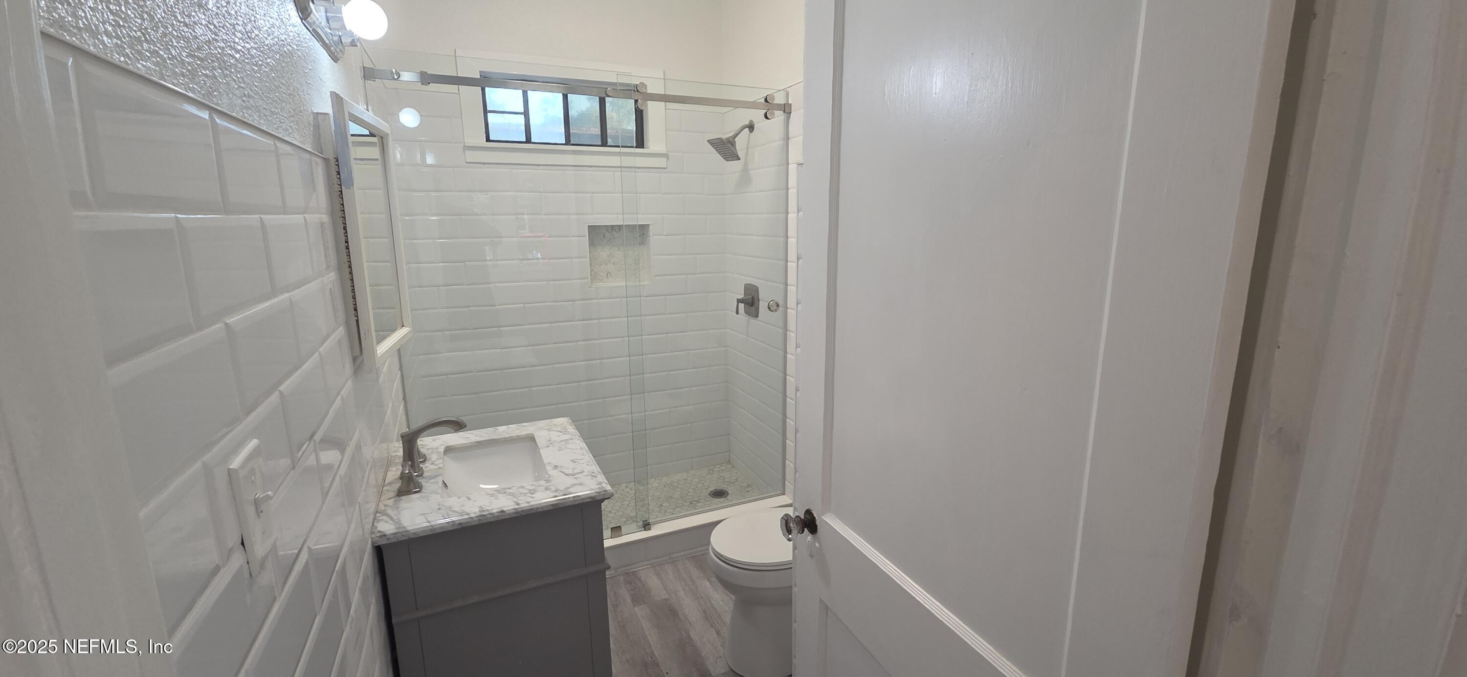 3849 Valencia Road Jacksonville, FL 32205 - Photo 20 of 30 a bathroom with a granite countertop sink a toilet and shower