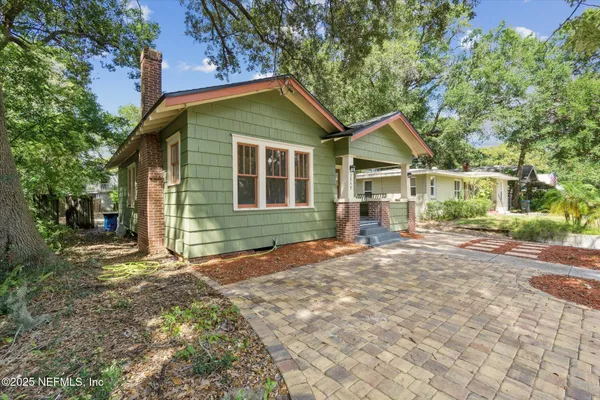 a view of a house with yard and a tree