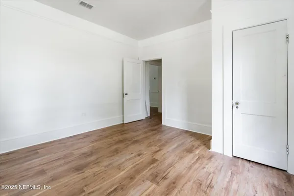 a view of an empty room with wooden floor