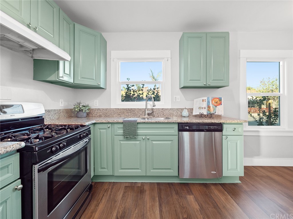 1096 Stanley Avenue Long Beach, CA 90804 - Photo 12 of 33 a kitchen with granite countertop a stove top oven sink and cabinets