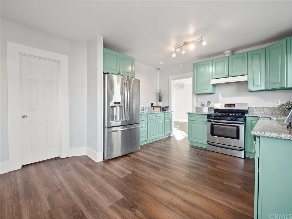 1096 Stanley Avenue Long Beach, CA 90804 - Photo 13 of 33 a kitchen with granite countertop a refrigerator and a stove top oven