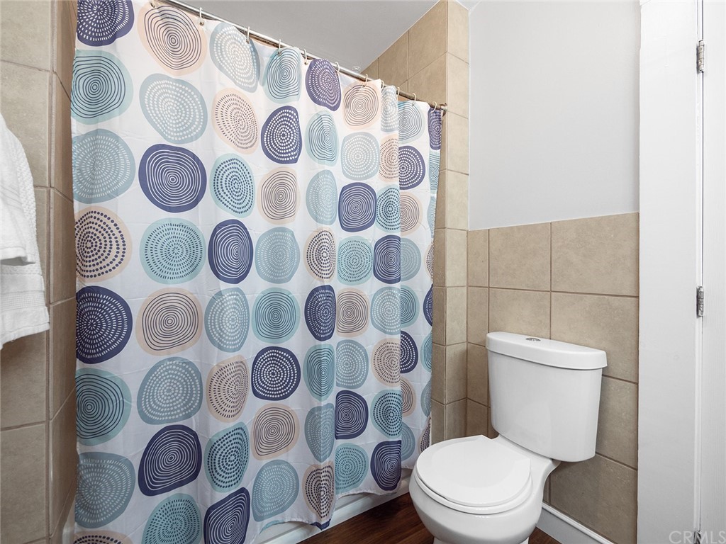 1096 Stanley Avenue Long Beach, CA 90804 - Photo 20 of 33 a white toilet sitting next to a shower curtain