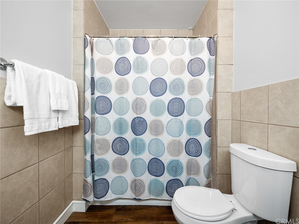 1096 Stanley Avenue Long Beach, CA 90804 - Photo 21 of 33 a white toilet sitting next to a shower curtain