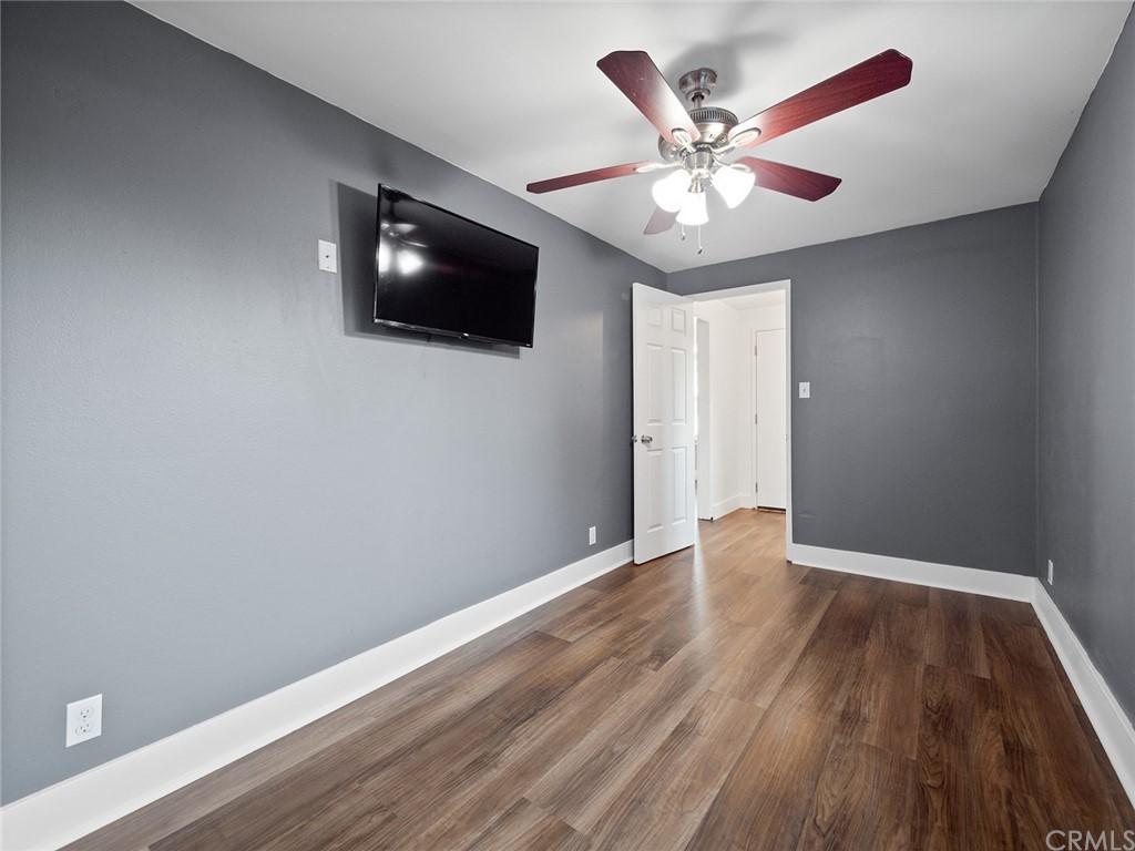1096 Stanley Avenue Long Beach, CA 90804 - Photo 23 of 33 a view of an empty room with wooden floor and a ceiling fan