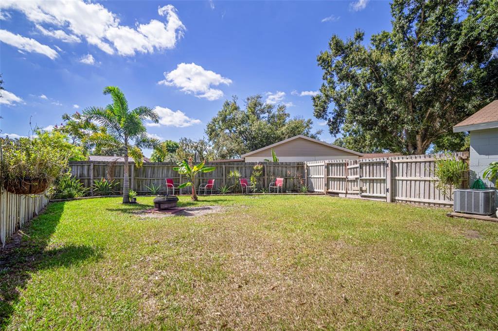 11305 Silverleaf Court Riverview, FL 33579 - Photo 35 of 39 a backyard of a house with table and chairs plants and large tree