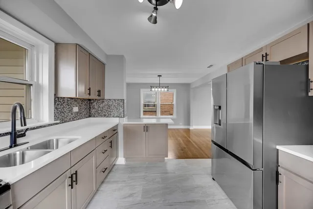 a kitchen with granite countertop a refrigerator sink and cabinets