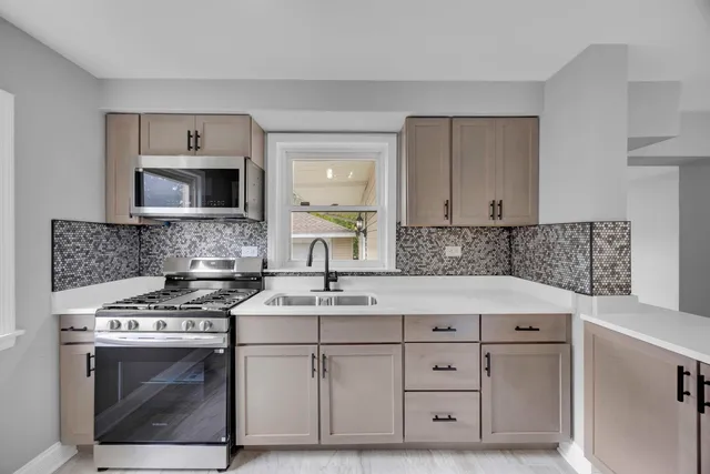 a kitchen with cabinets appliances a sink and a counter top space