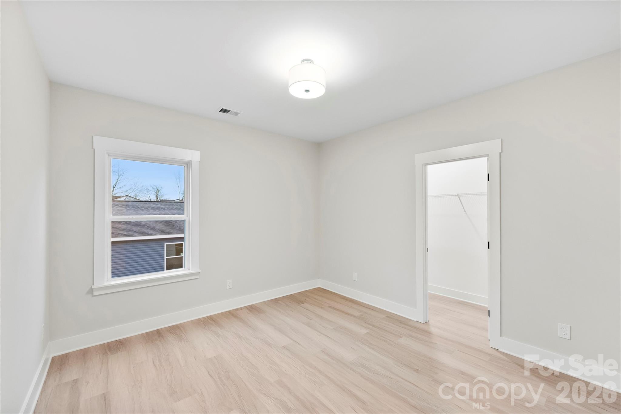 551 Perry Road Troutman, NC 28166 - Photo 29 of 47 a view of an empty room with a window and wooden floor