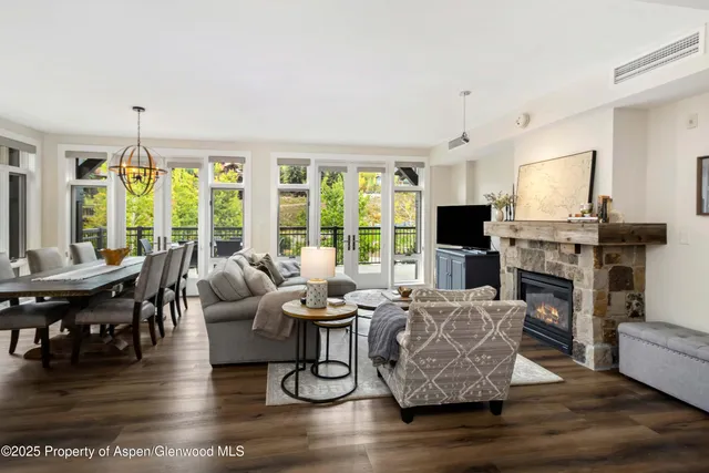 a living room with fireplace furniture and a large window