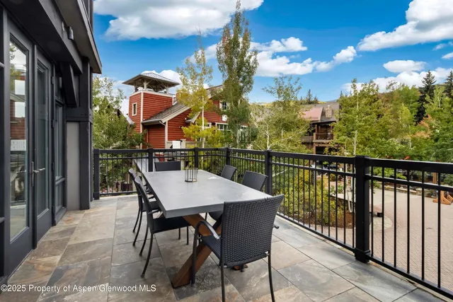a view of a balcony dining table and chairs with wooden floor