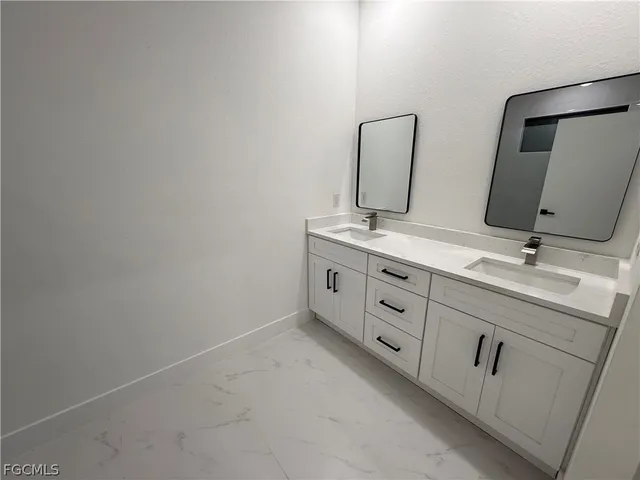 a bathroom with a double vanity sink and mirror