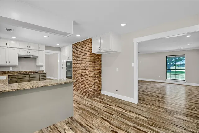 a kitchen with granite countertop a sink and a stove